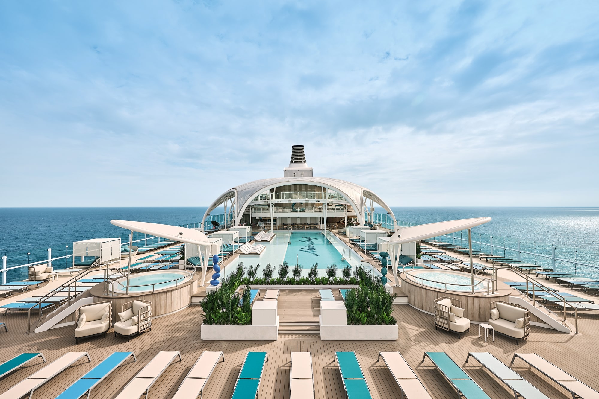 http://Pont%20supérieur%20d’un%20bateau%20de%20croisière%20avec%20piscine%20centrale,%20jacuzzis%20et%20transats%20face%20à%20l’océan