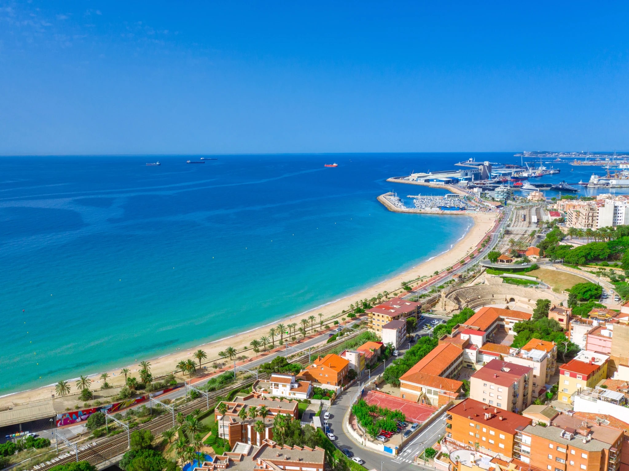 http://Vue%20aérienne%20d'une%20plage%20urbaine%20avec%20palmiers%20et%20port%20maritime%20sur%20la%20côte%20espagnole