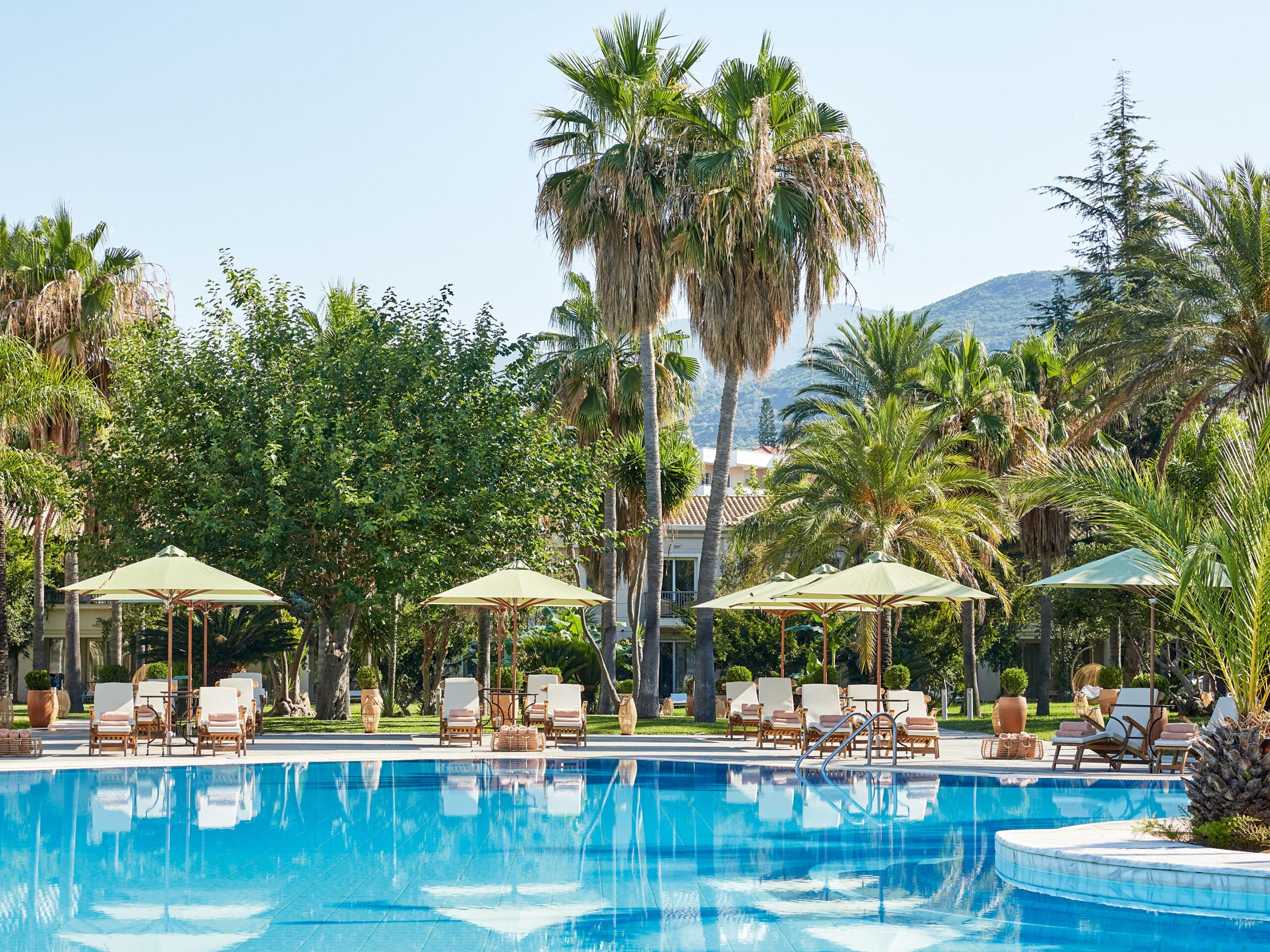 http://Piscine%20bordée%20de%20palmiers%20et%20transats%20dans%20un%20hôtel%20de%20luxe