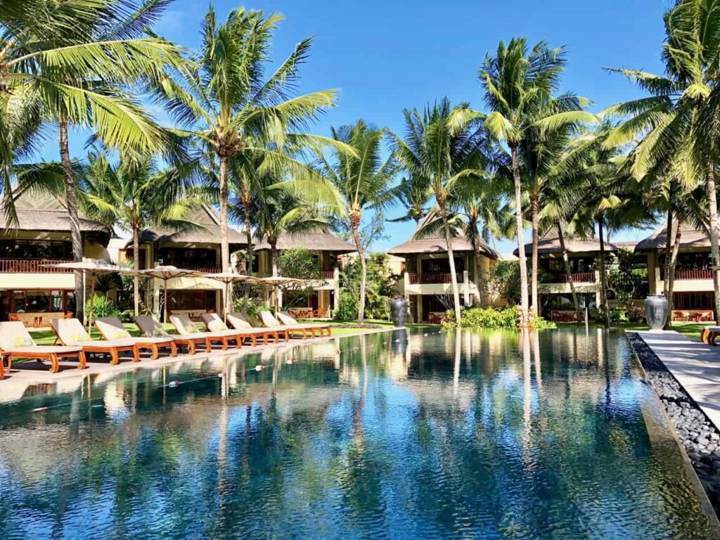Piscine extérieure entourée de palmiers dans un hôtel de luxe tropical
