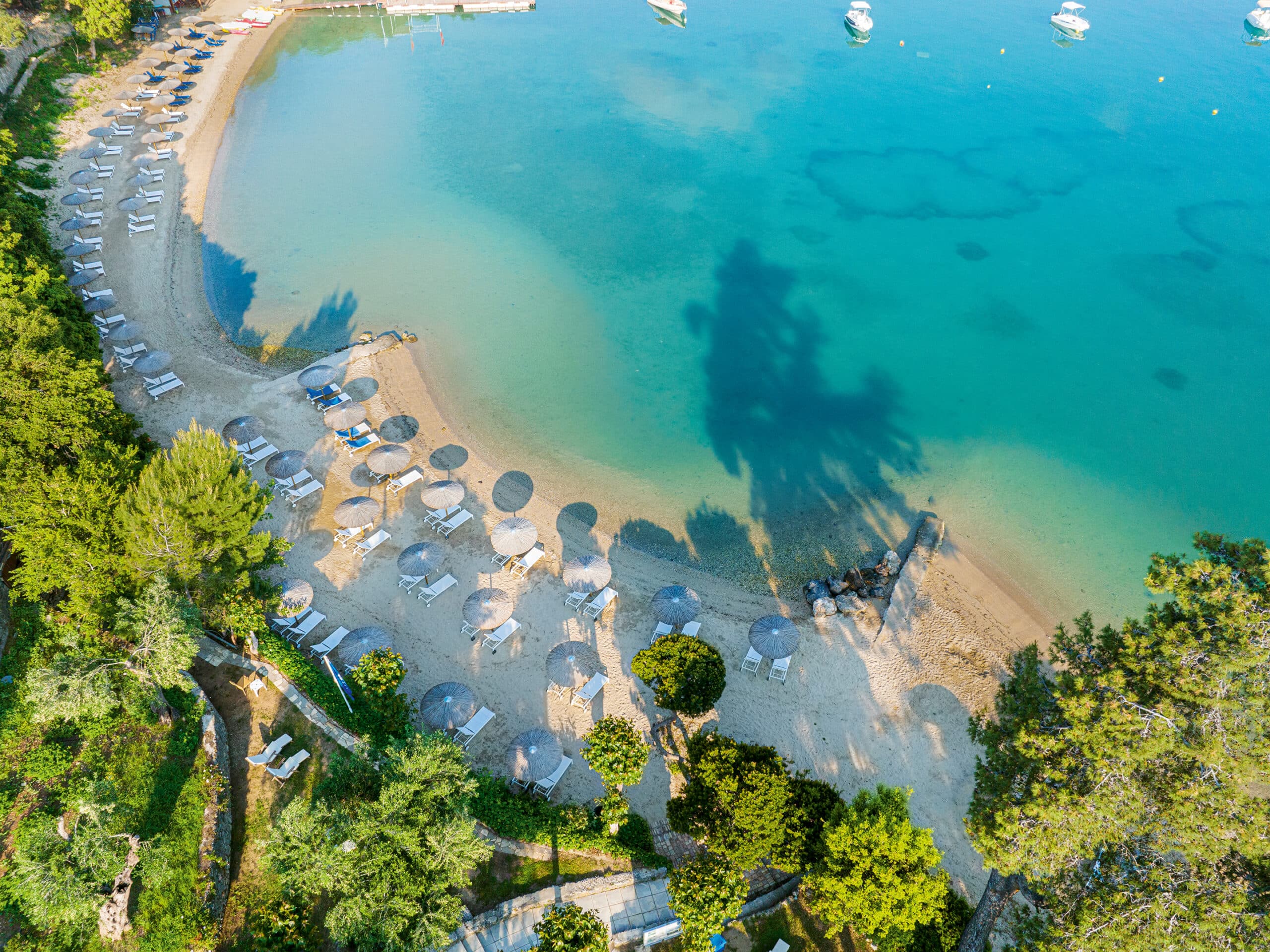 http://Plage%20de%20sable%20fin%20bordée%20de%20chaises%20longues%20et%20parasols,%20eau%20turquoise