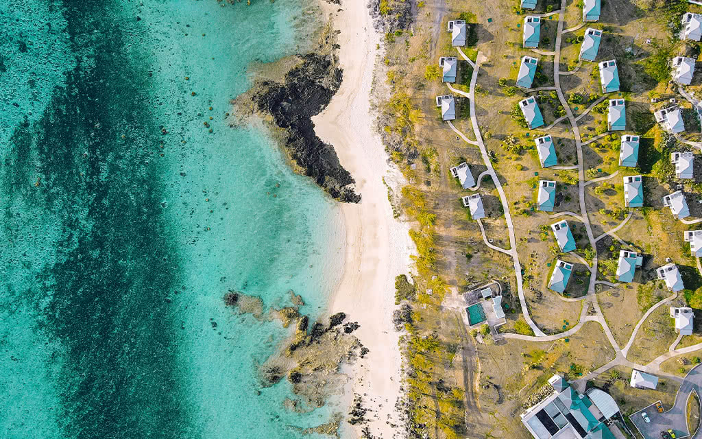 http://Vue%20aérienne%20d’un%20resort%20balnéaire%20à%20l’île%20Maurice%20avec%20plage%20de%20sable%20blanc%20et%20villas%20en%20bord%20de%20mer.