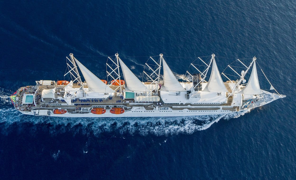http://Vue%20aérienne%20d’un%20grand%20voilier%20de%20croisière%20à%20voiles%20blanches%20naviguant%20en%20pleine%20mer.