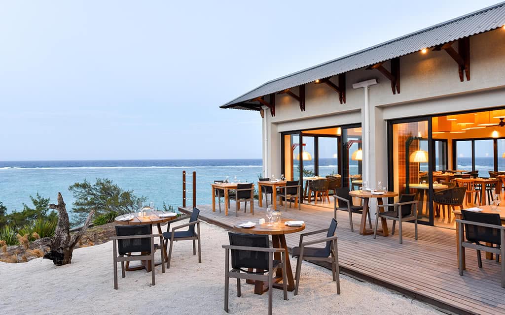 http://Terrasse%20de%20restaurant%20face%20à%20la%20mer%20avec%20mobilier%20en%20bois%20à%20l'île%20Maurice.