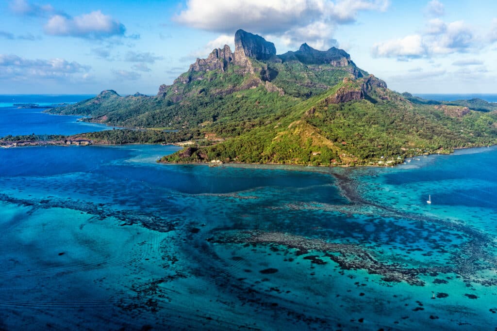Vue aérienne du mont Otemanu entouré d’un lagon turquoise à Bora Bora.