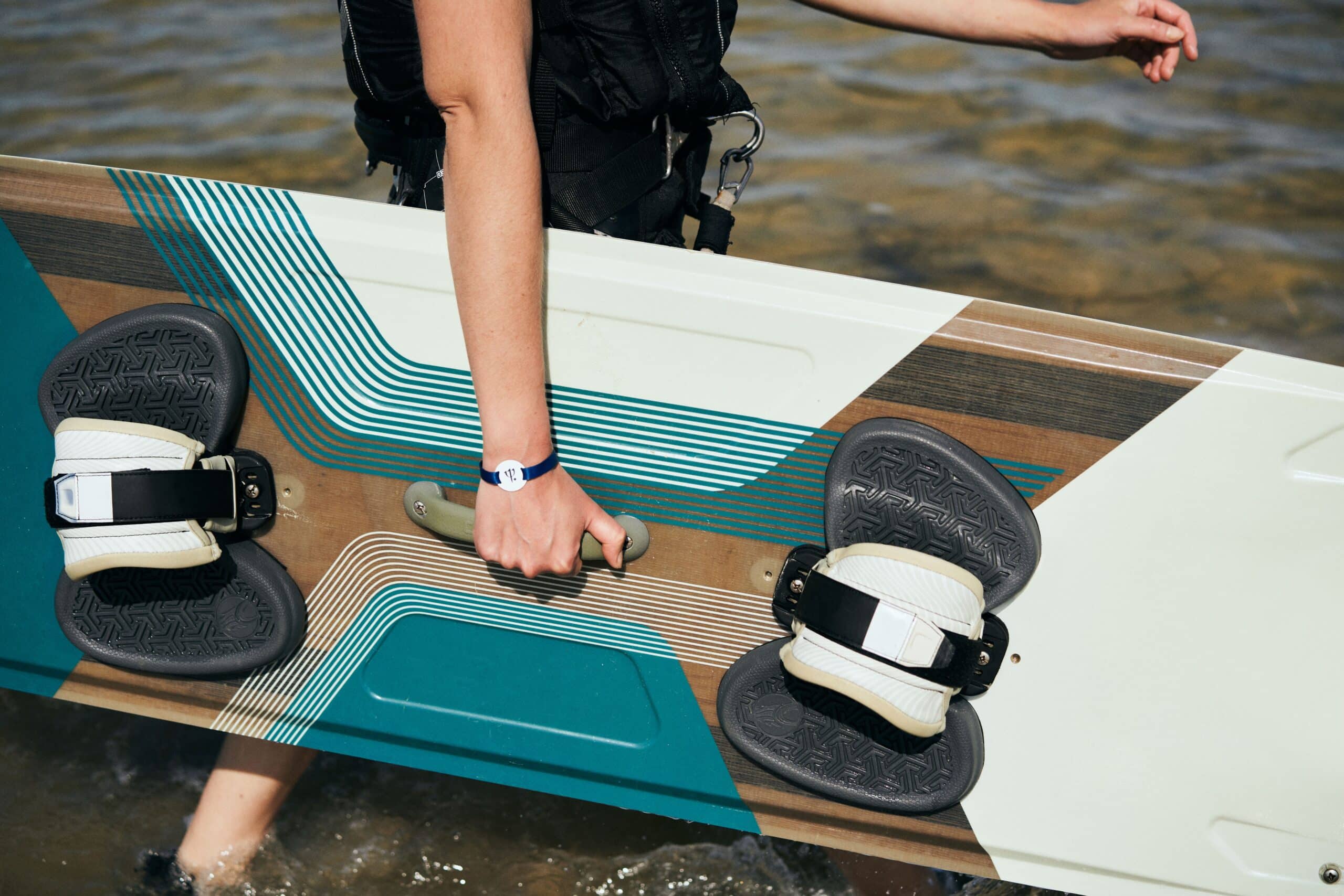 http://Personne%20tenant%20une%20planche%20de%20sport%20nautique%20au%20bord%20de%20l’eau