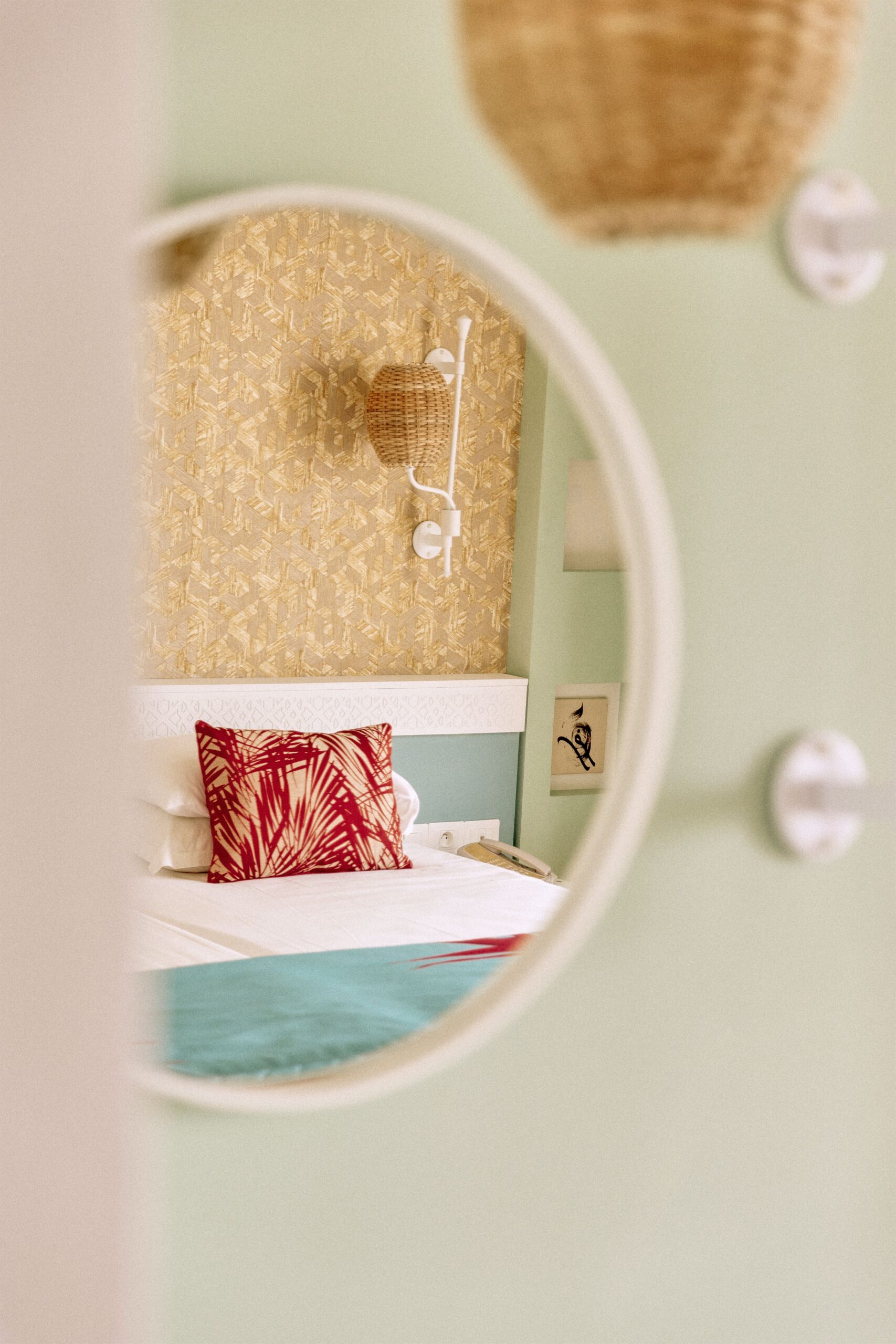 http://Reflet%20d’une%20chambre%20d’hôtel%20décorée%20avec%20goût%20vu%20à%20travers%20un%20miroir%20rond