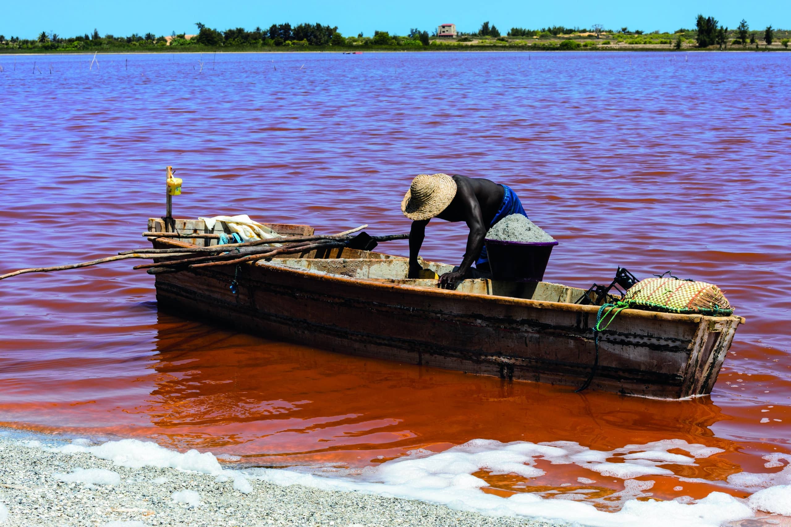 http://Homme%20récoltant%20du%20sel%20dans%20une%20pirogue%20sur%20les%20eaux%20roses%20du%20lac%20Retba%20au%20Sénégal.