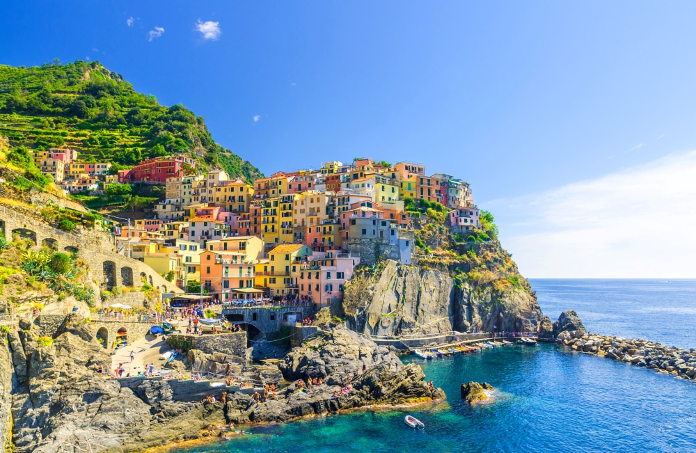 Vue panoramique du village de Manarola perché sur les falaises de la côte ligure en Italie, sous un ciel ensoleillé