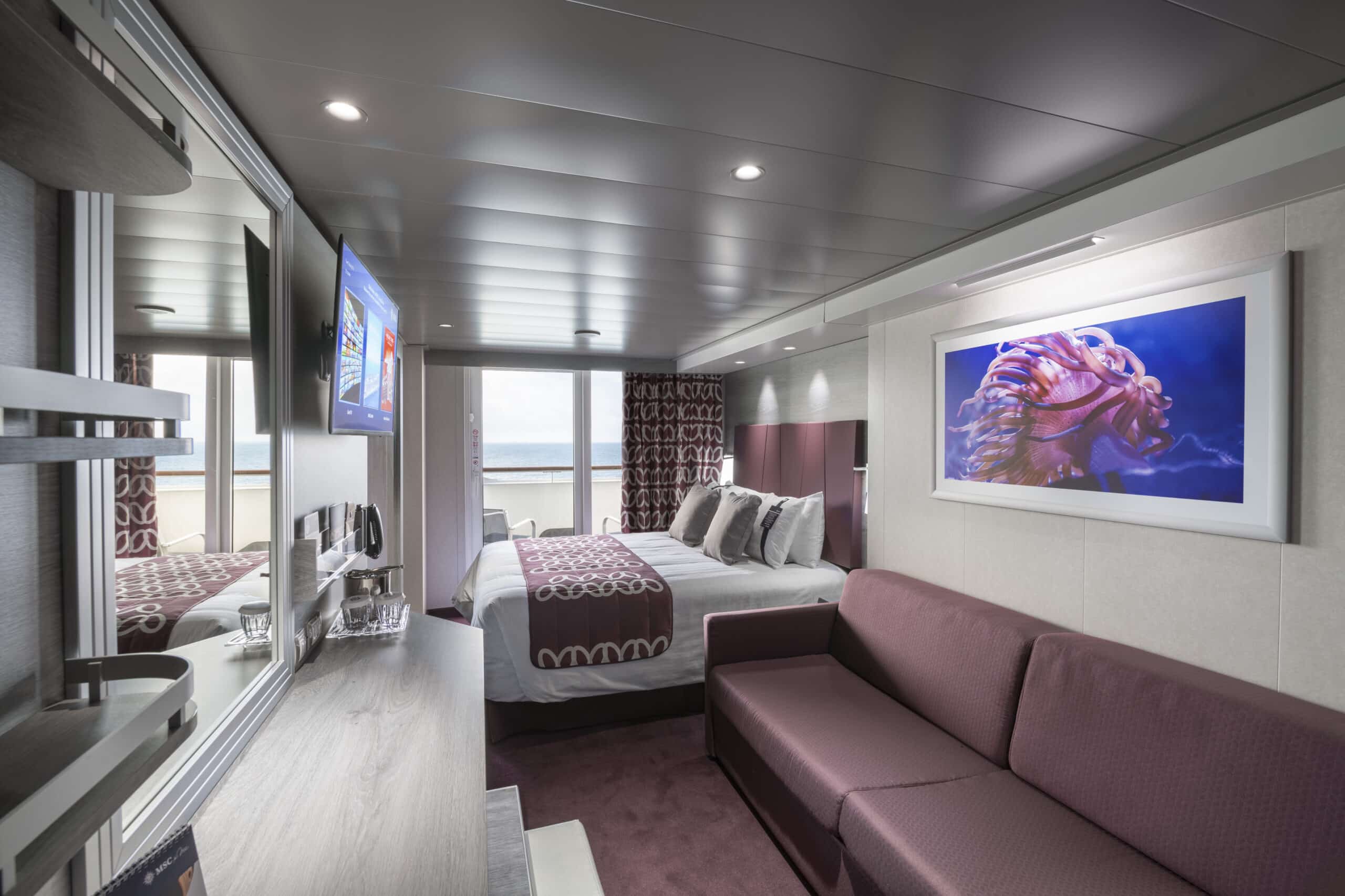 http://Cabine%20moderne%20avec%20lit%20double,%20canapé%20et%20balcon%20sur%20un%20navire%20MSC