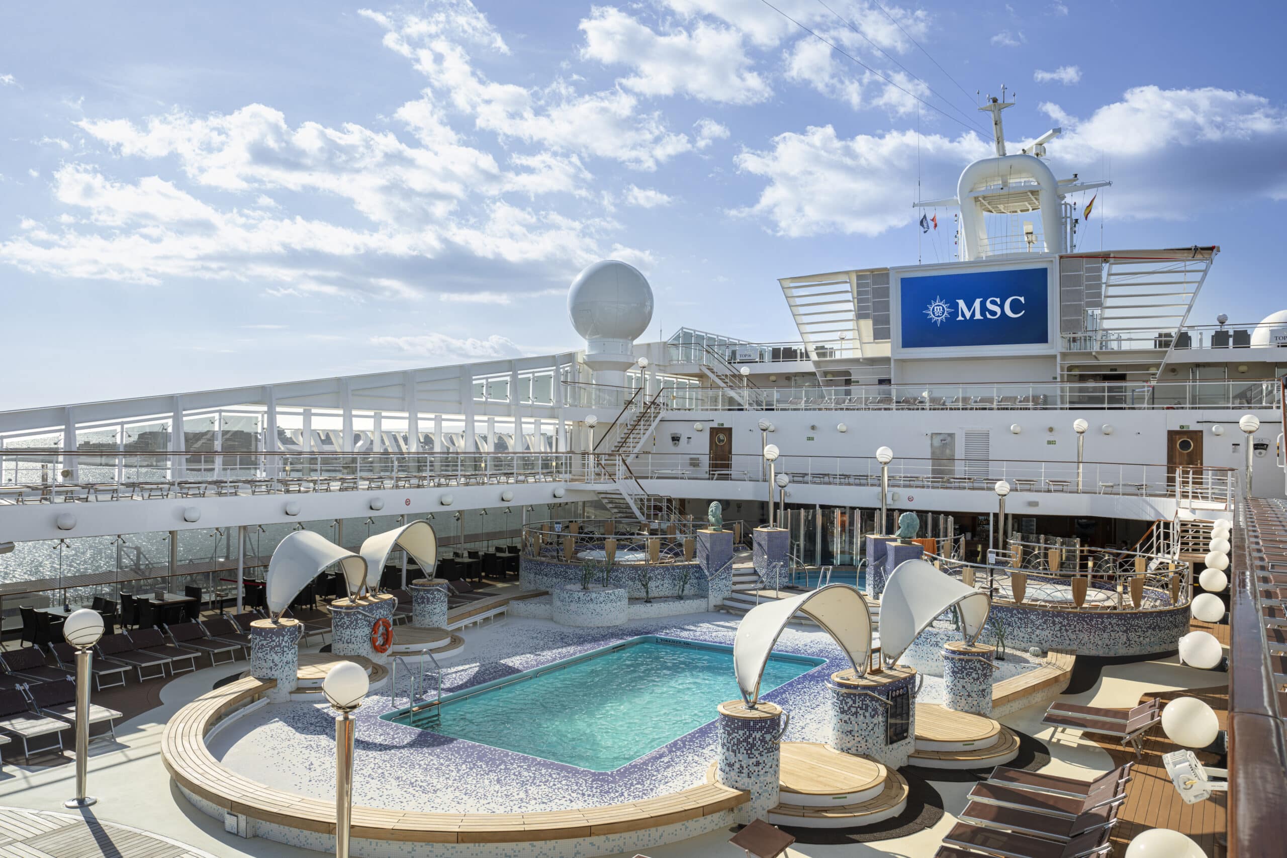 Piscine extérieure du MSC Orchestra entourée de transats et d'espaces de détente sur le pont du navire.