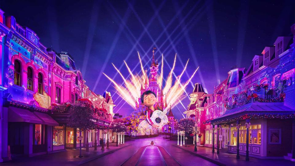 Main Street Disneyland Paris illuminée avec projections colorées et feux d’artifice sur le château