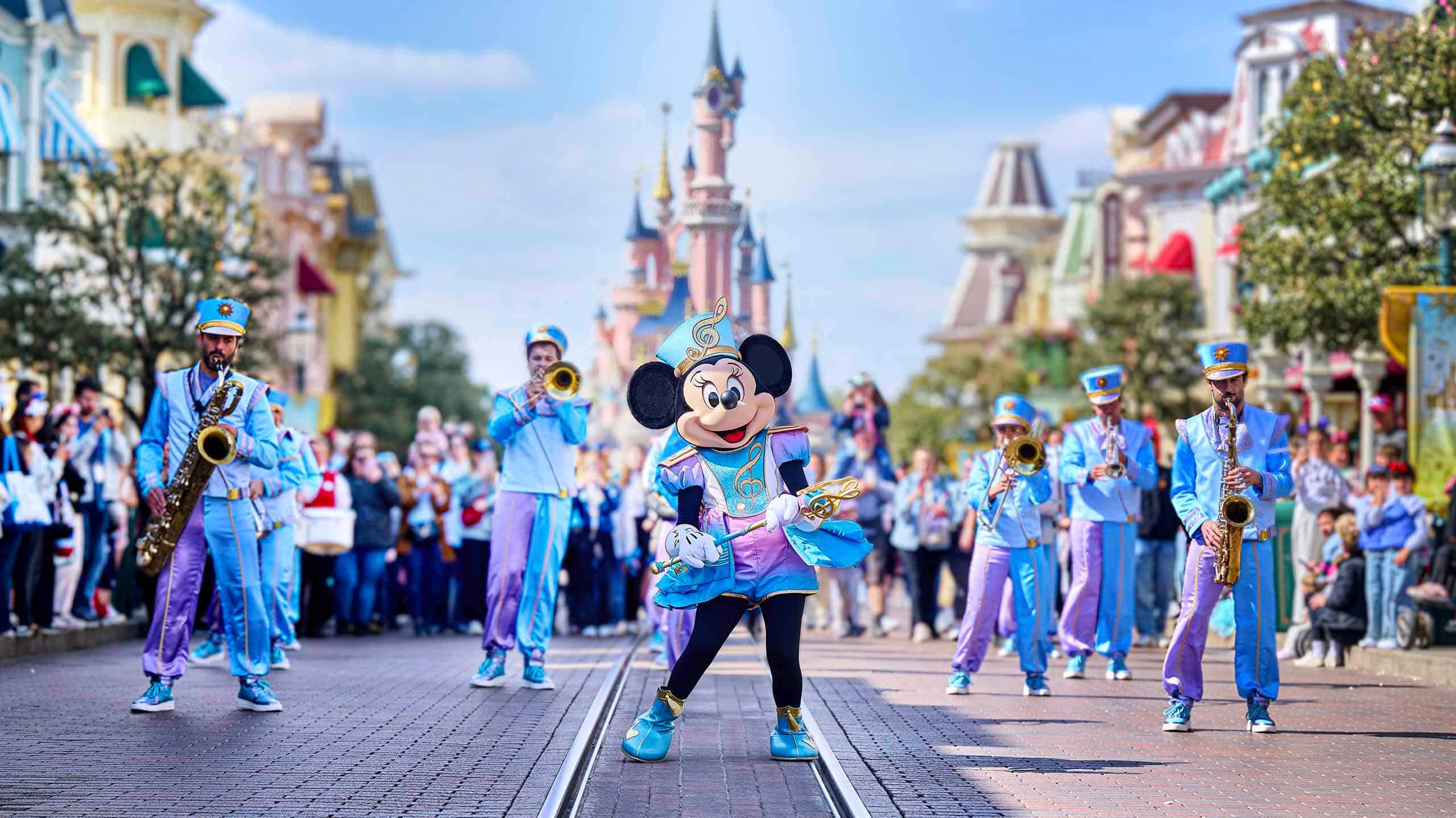 http://Minnie%20Mouse%20accompagnée%20d’une%20fanfare%20lors%20d’une%20parade%20sur%20Main%20Street%20à%20Disneyland%20Paris