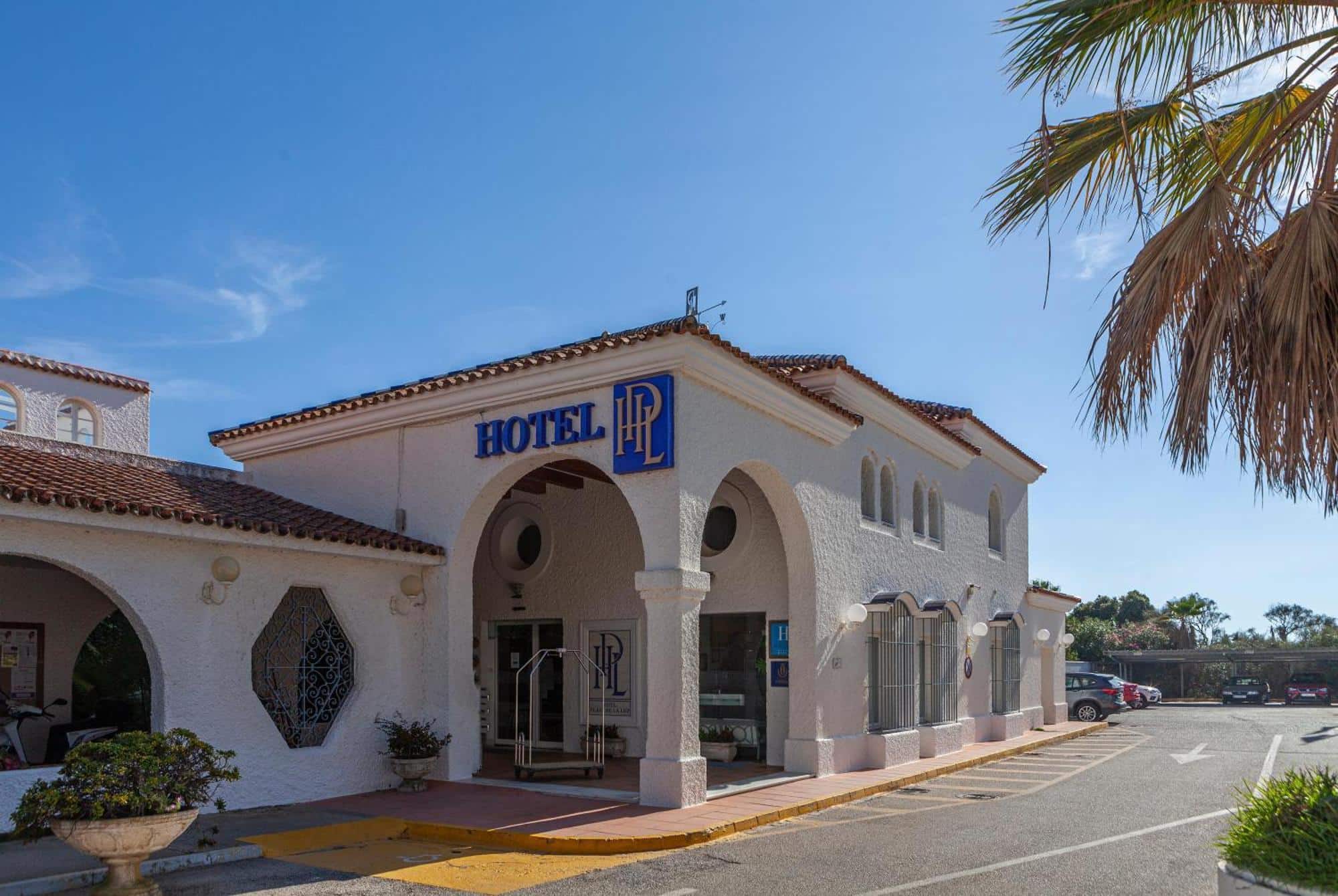 http://Entrée%20principale%20de%20l’hôtel%20La%20Playa%20avec%20architecture%20méditerranéenne%20et%20enseigne%20visible.