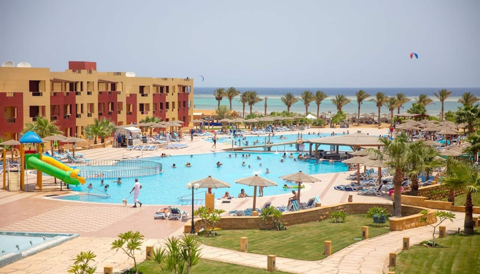http://Vue%20d’ensemble%20d’un%20hôtel%20en%20bord%20de%20mer%20avec%20piscines,%20palmiers%20et%20plage%20sur%20la%20mer%20Rouge.