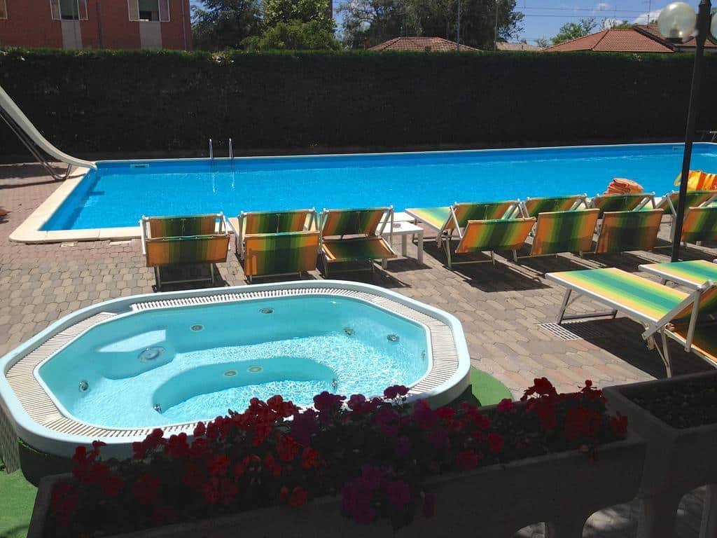 http://Piscine%20extérieure%20avec%20jacuzzi,%20transats%20colorés%20et%20ambiance%20détente%20dans%20un%20hôtel%20en%20Italie.