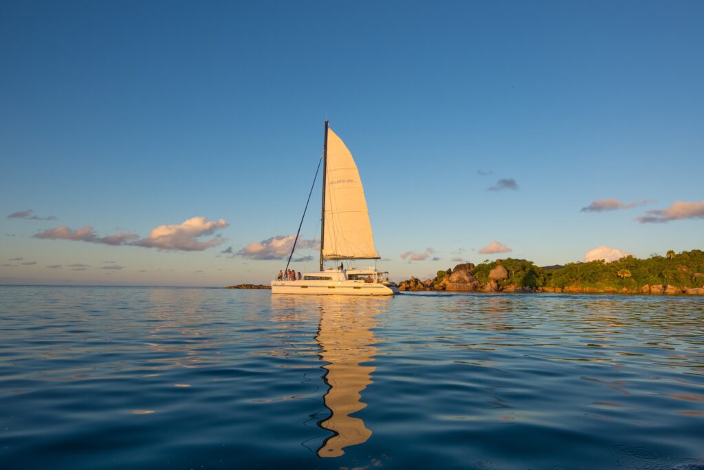 Catamaran naviguant au coucher du soleil dans les eaux paisibles des Seychelles