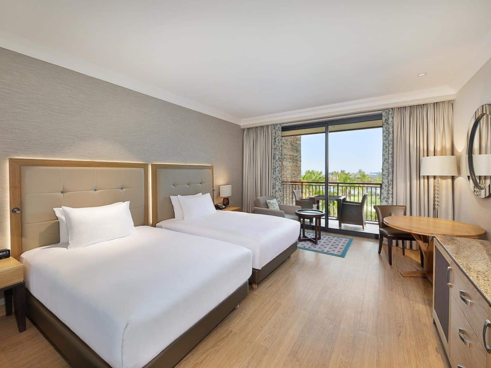http://Chambre%20d’hôtel%20spacieuse%20avec%20lits%20jumeaux%20et%20balcon%20donnant%20sur%20les%20palmiers%20au%20Cap-Vert