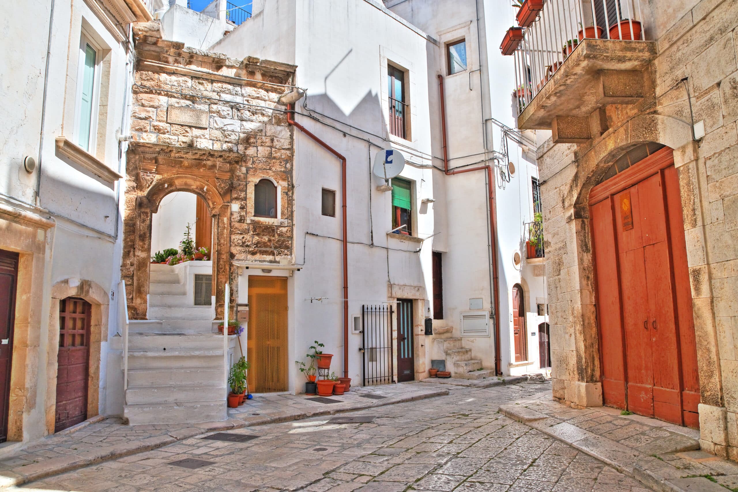 http://Maisons%20blanches%20et%20ruelle%20calme%20dans%20le%20centre%20historique%20de%20Monopoli%20avec%20arc%20en%20pierre.