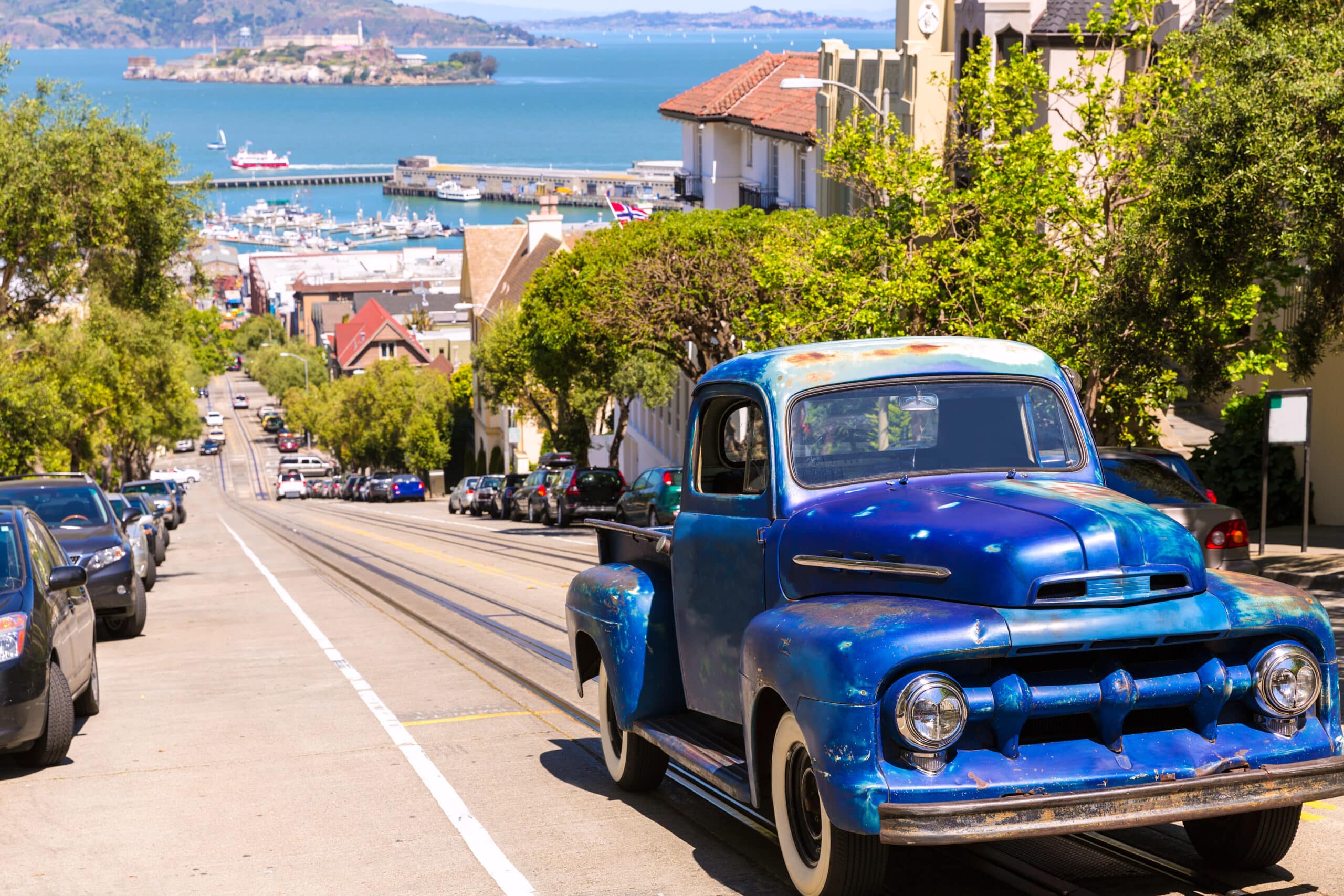 http://Pick-up%20vintage%20dans%20une%20rue%20en%20pente%20de%20San%20Francisco%20avec%20vue%20sur%20Alcatraz