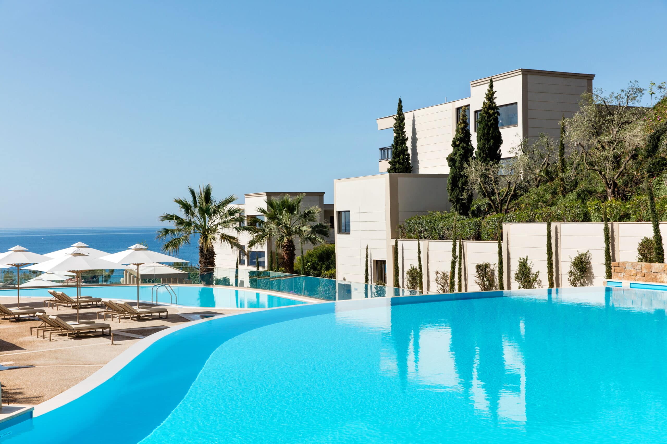 http://Piscine%20à%20débordement%20dans%20un%20hôtel%20en%20bord%20de%20mer%20avec%20transats%20et%20palmiers