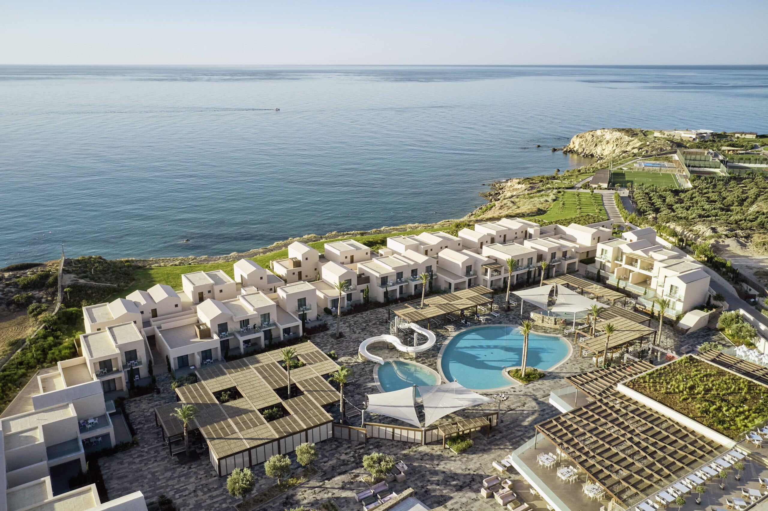 http://Vue%20aérienne%20d’un%20complexe%20hôtelier%20de%20luxe%20en%20bord%20de%20mer%20avec%20piscine%20centrale.