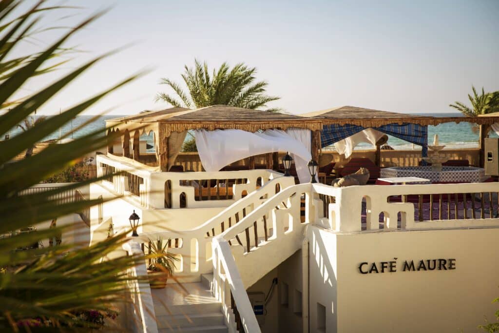 Café maure typique avec décoration orientale et vue sur la mer.