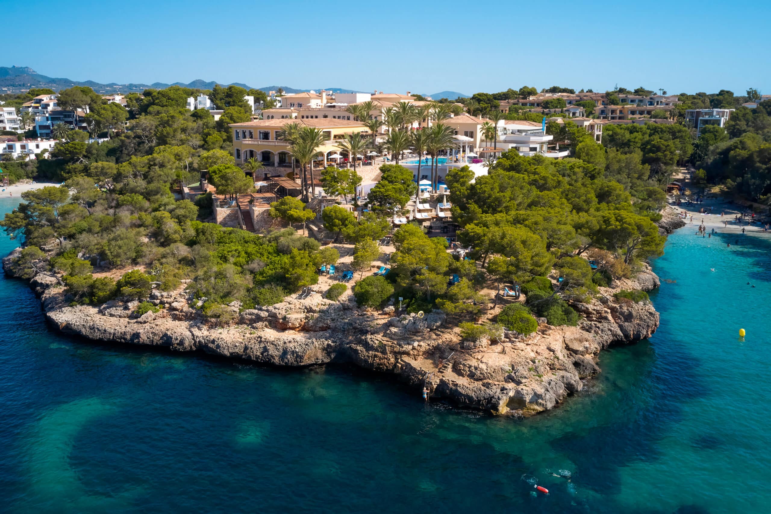 http://Vue%20aérienne%20d’un%20hôtel%20niché%20sur%20une%20presqu’île%20entourée%20d’eaux%20turquoise%20à%20Majorque.