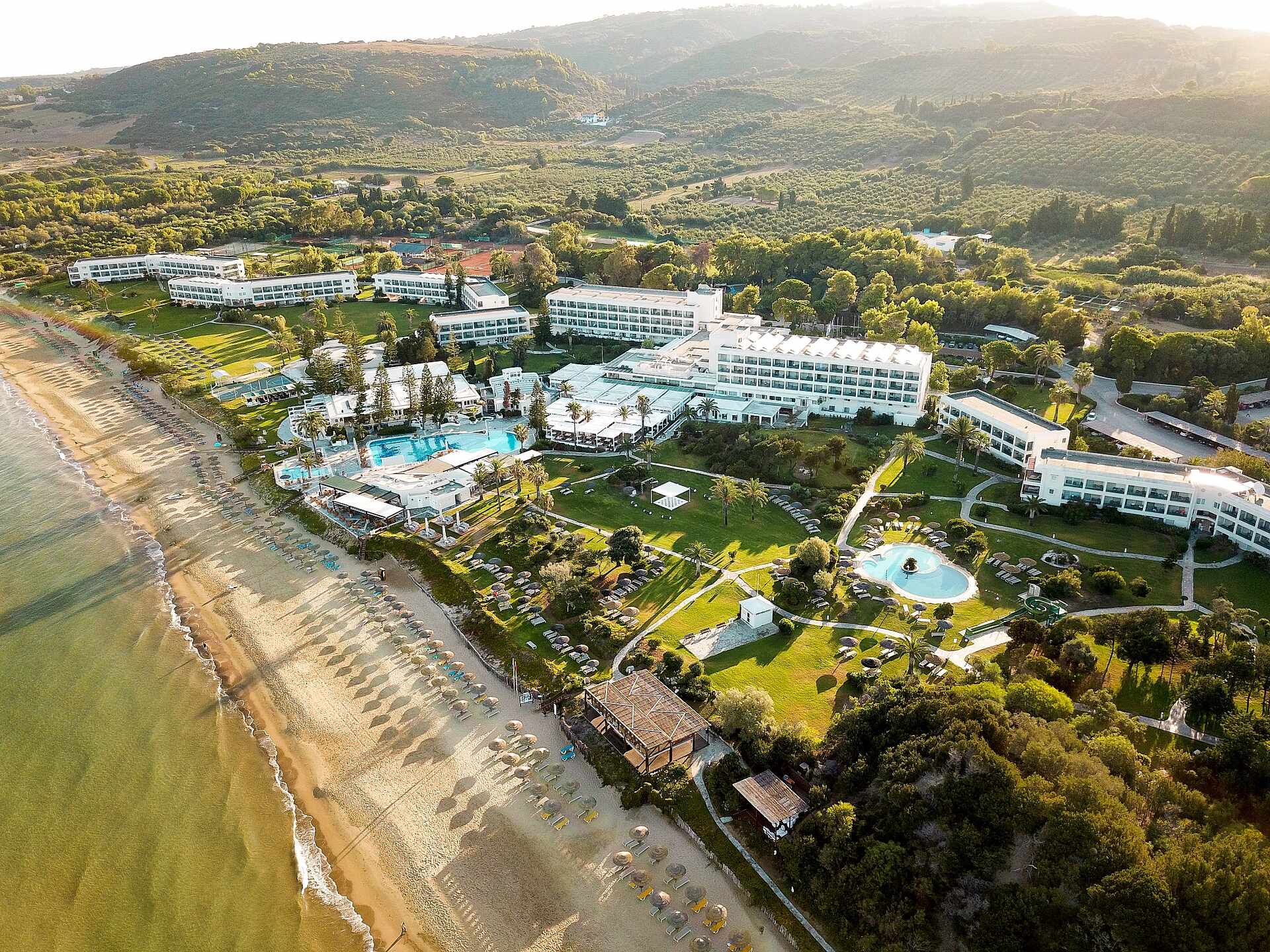 http://Vue%20aérienne%20d’un%20complexe%20hôtelier%20en%20bord%20de%20mer%20avec%20accès%20direct%20à%20une%20plage%20de%20sable.