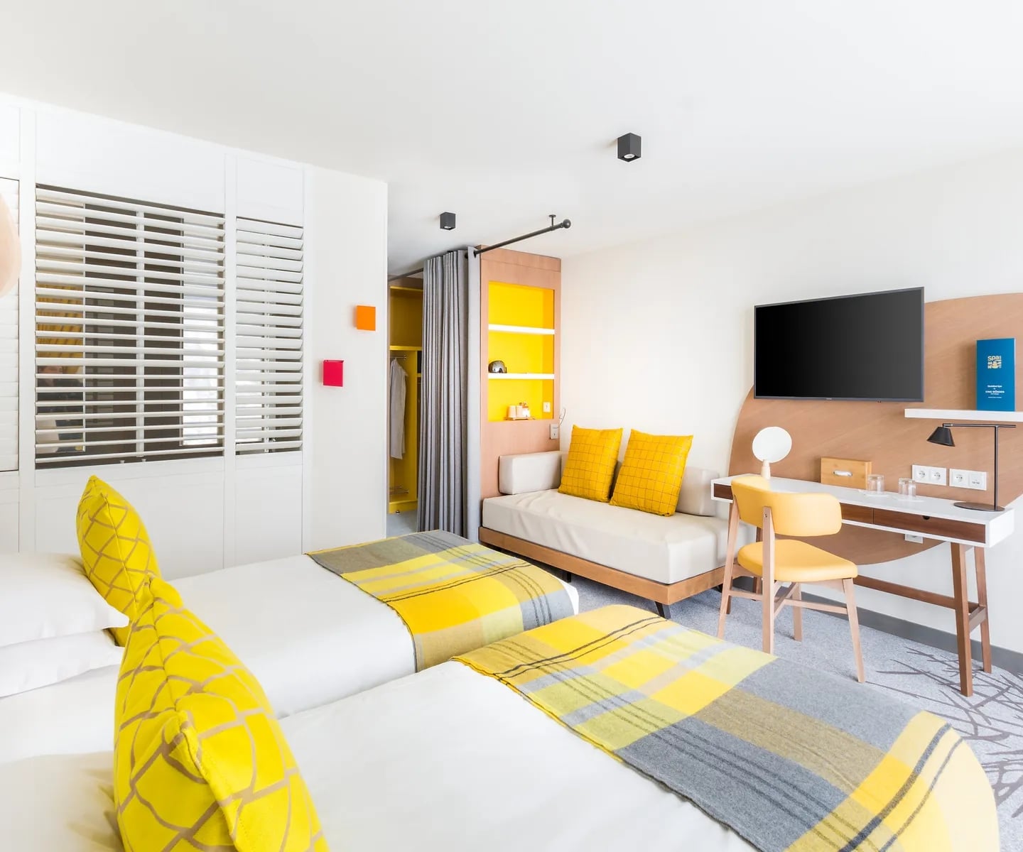 http://Chambre%20d’hôtel%20contemporaine%20avec%20lits%20jumeaux%20et%20décoration%20jaune%20lumineuse