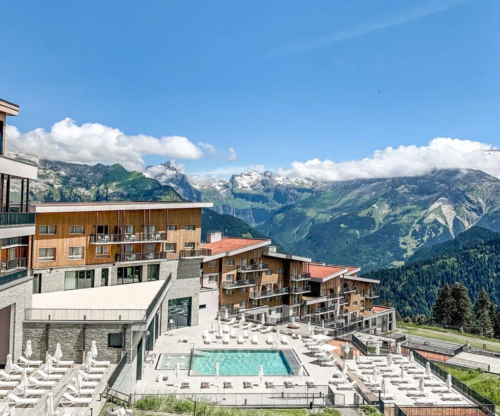 Complexe hôtelier avec piscine extérieure face aux montagnes