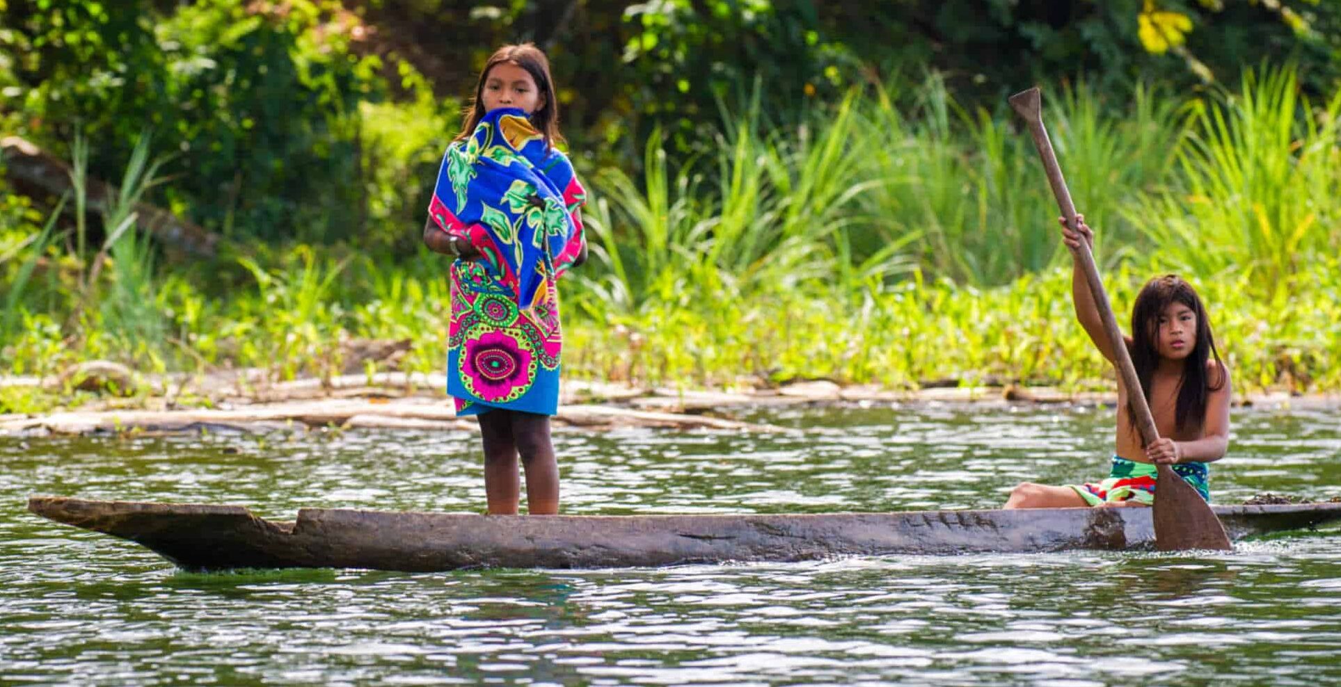 http://Enfants%20sur%20une%20pirogue%20traditionnelle%20sur%20une%20rivière%20en%20forêt%20amazonienne
