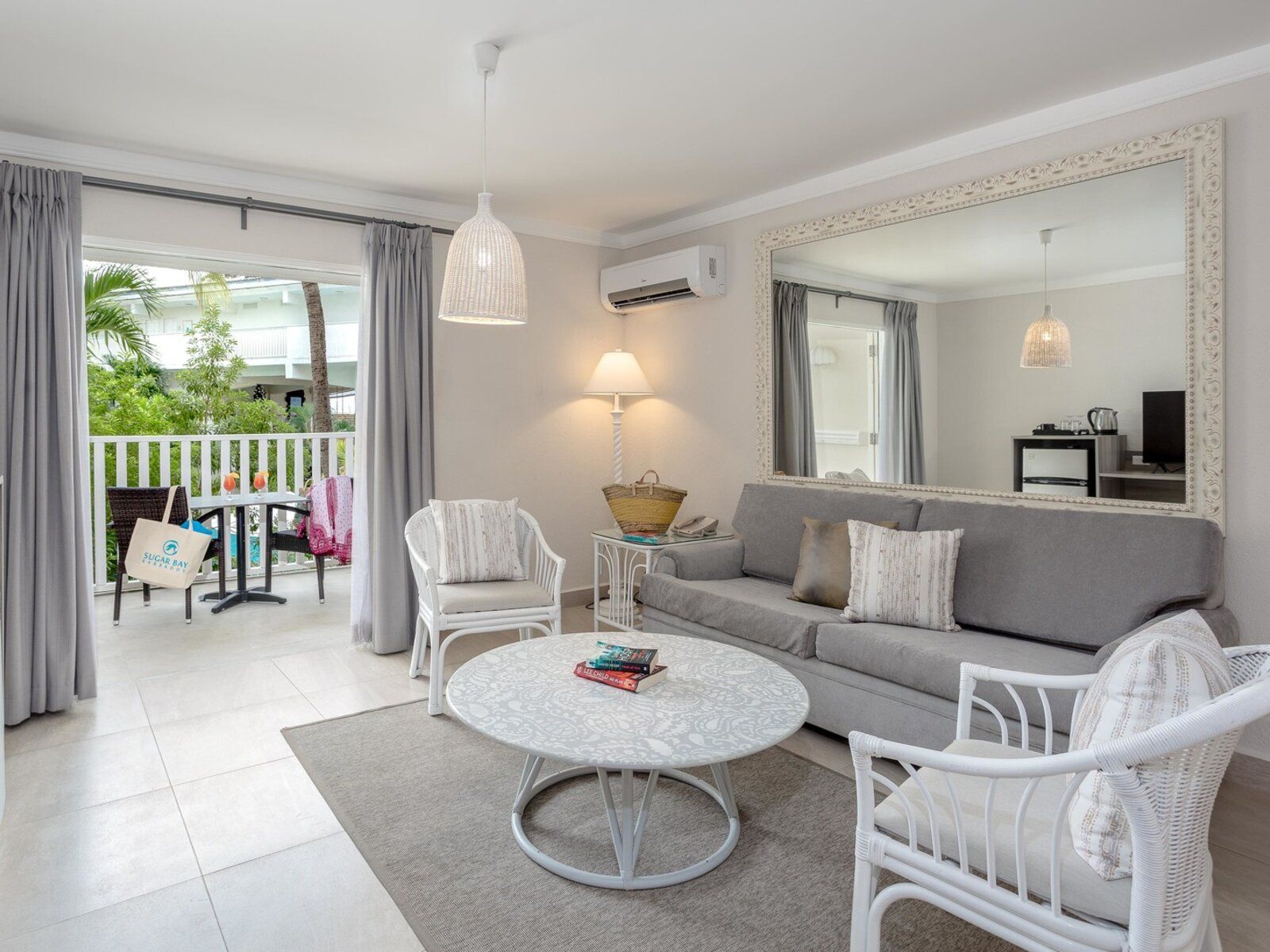http://Salon%20lumineux%20avec%20canapé%20et%20accès%20à%20un%20balcon%20avec%20vue%20sur%20jardin%20tropical