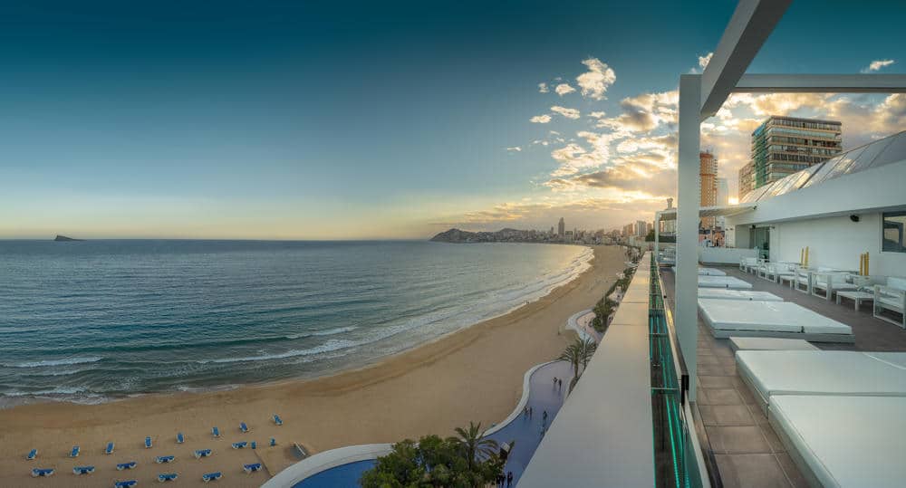 http://Terrasse%20d’hôtel%20moderne%20surplombant%20une%20plage%20et%20la%20mer%20au%20coucher%20du%20soleil