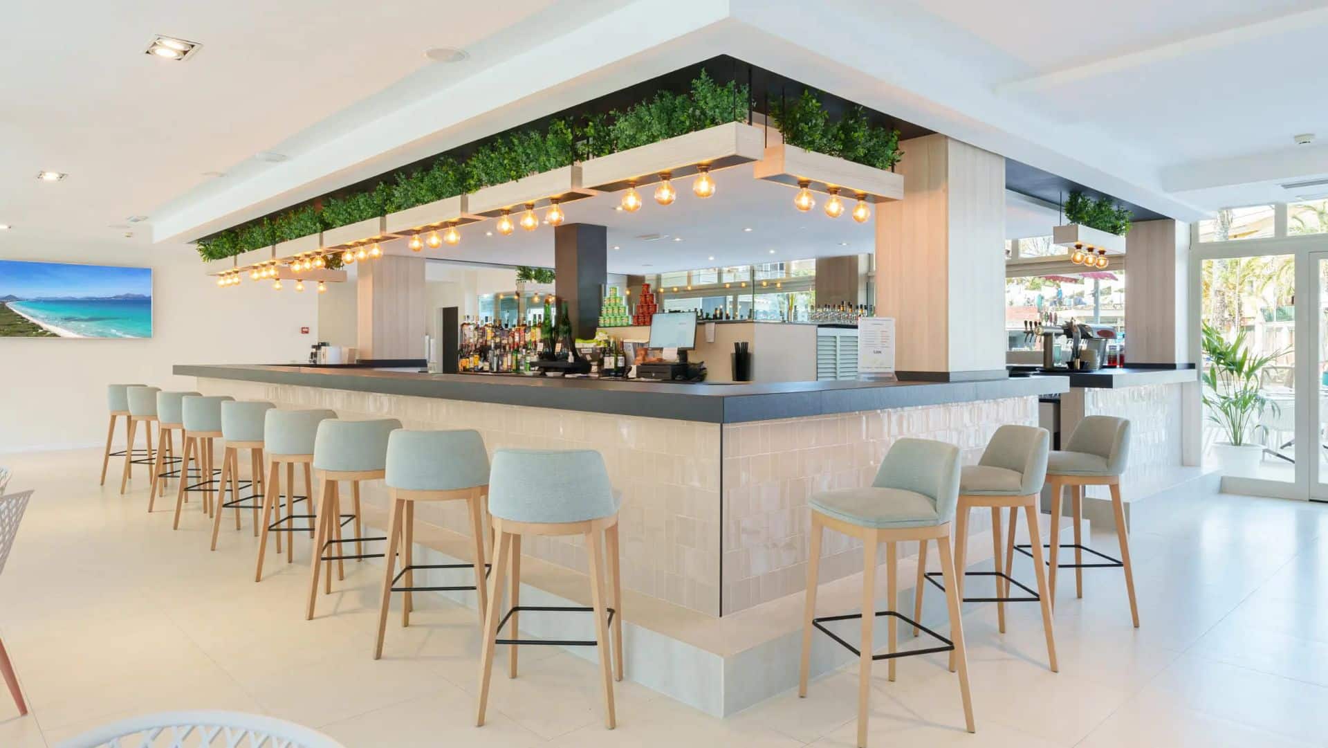 http://Bar%20d’hôtel%20avec%20tabourets%20hauts,%20éclairage%20chaleureux%20et%20décoration%20contemporaine