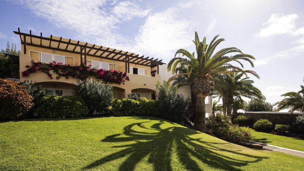 Hôtel entouré de palmiers avec jardin verdoyant