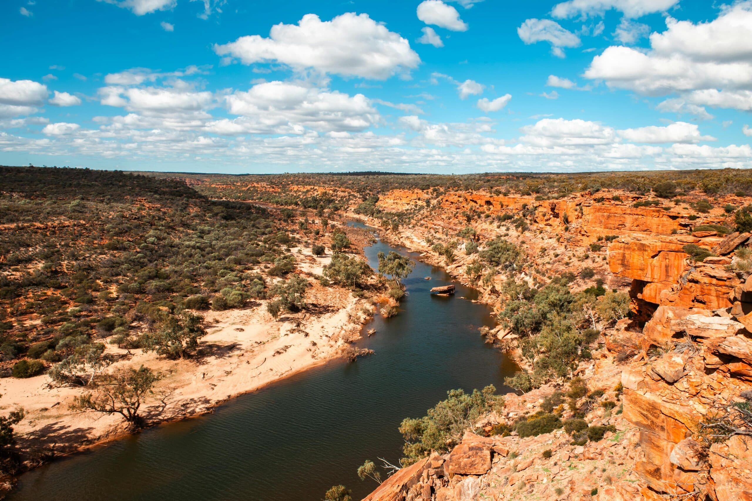 http://Rivière%20serpentant%20entre%20falaises%20rouges%20et%20végétation%20aride%20dans%20l’outback%20australien