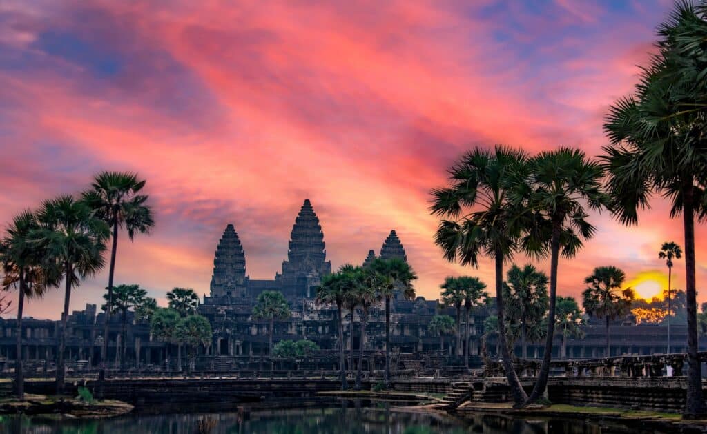 Temple d’Angkor Wat avec palmiers au coucher du soleil ciel rose Cambodge