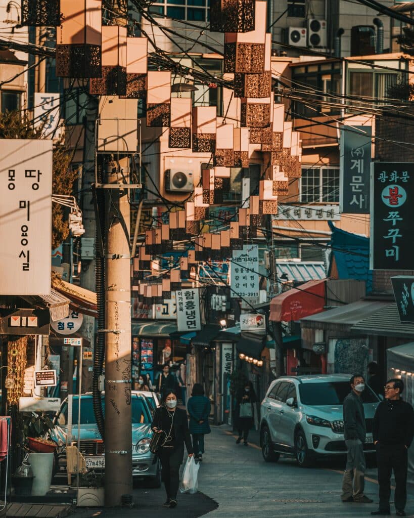 Rue étroite de Séoul décorée de lanternes avec passants et boutiques locales
