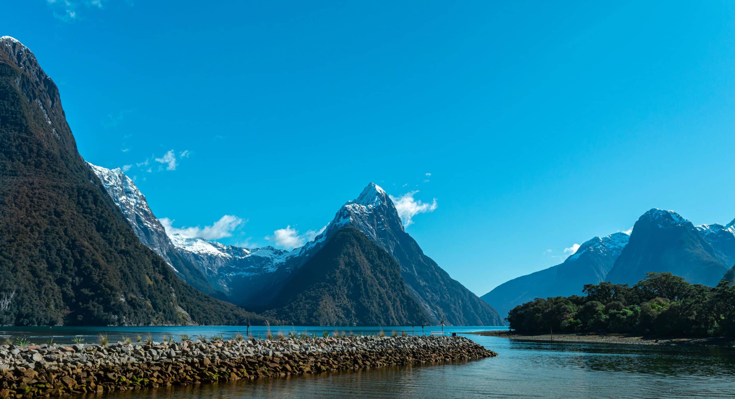 http://Paysage%20de%20Milford%20Sound%20avec%20montagnes%20escarpées,%20eau%20calme%20et%20ciel%20bleu%20en%20Nouvelle-Zélande