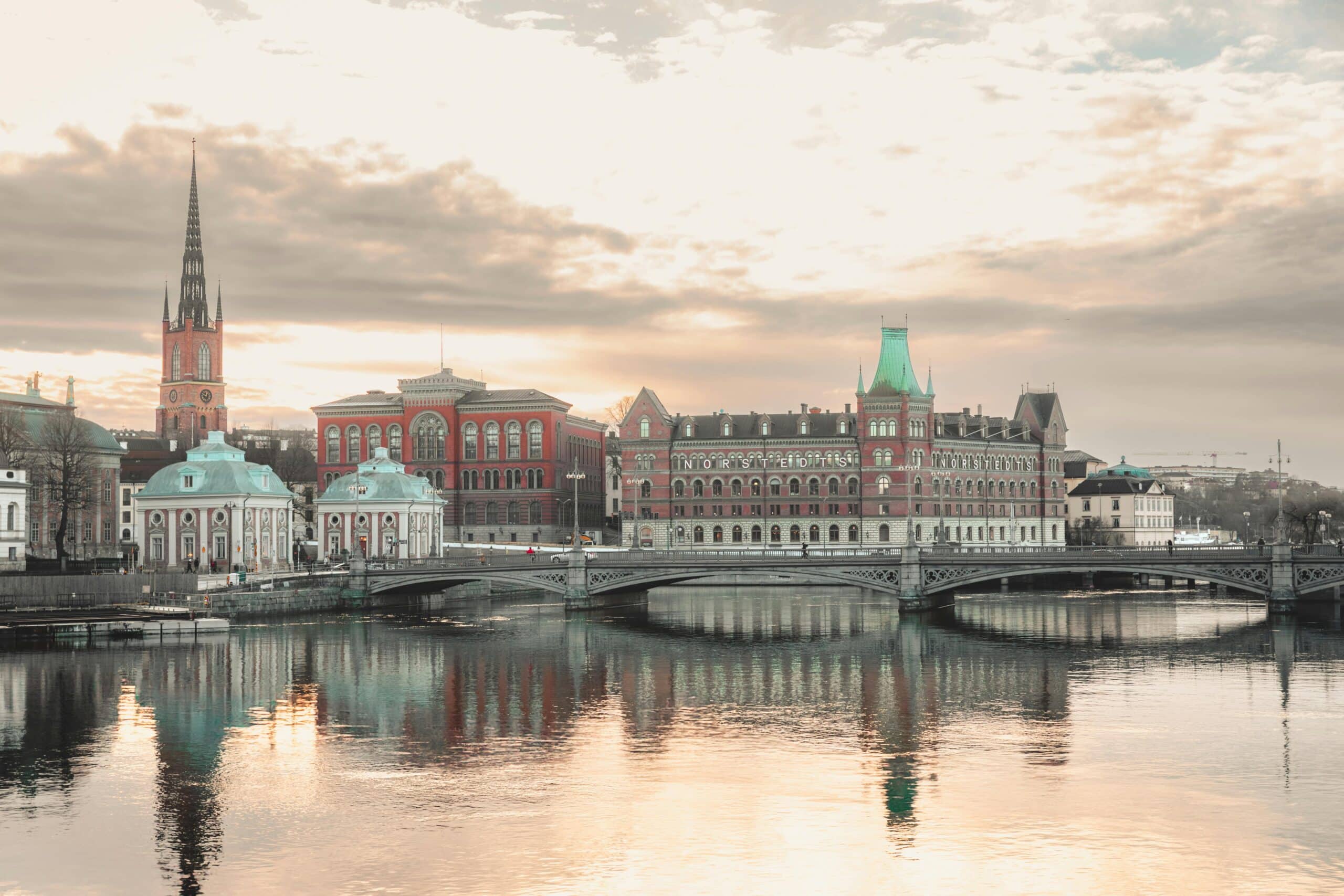 http://Vue%20du%20centre%20historique%20de%20Stockholm%20avec%20pont,%20église%20et%20bâtiments%20reflétés%20sur%20l’eau