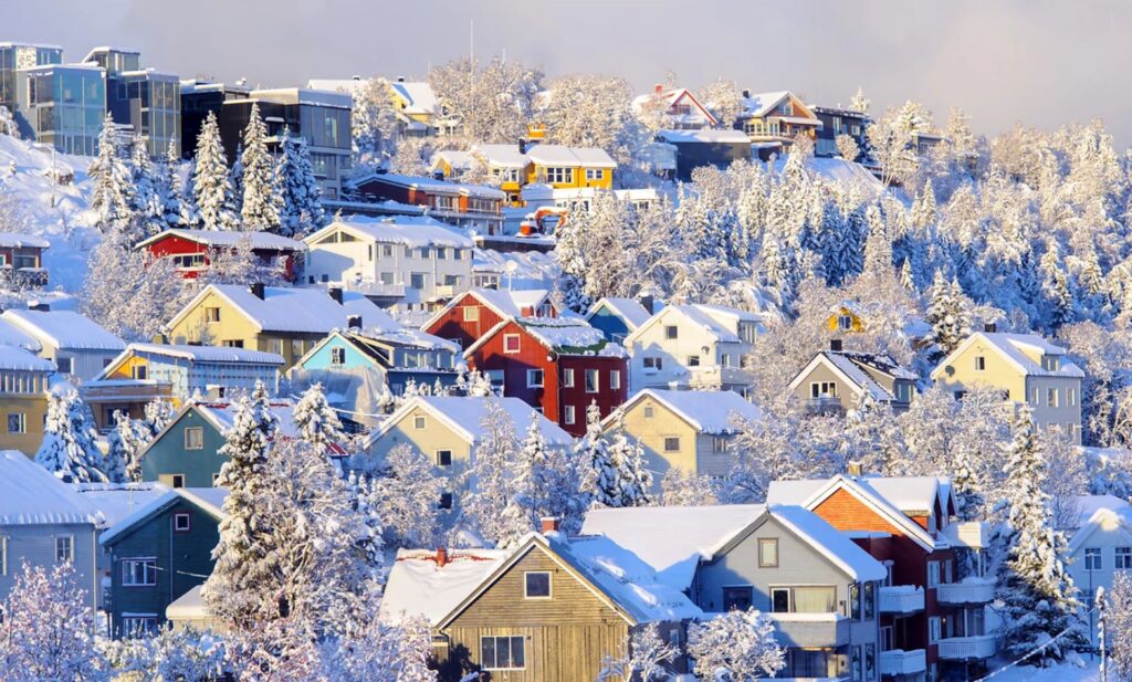 Maisons colorées couvertes de neige dans un village scandinave en hiver