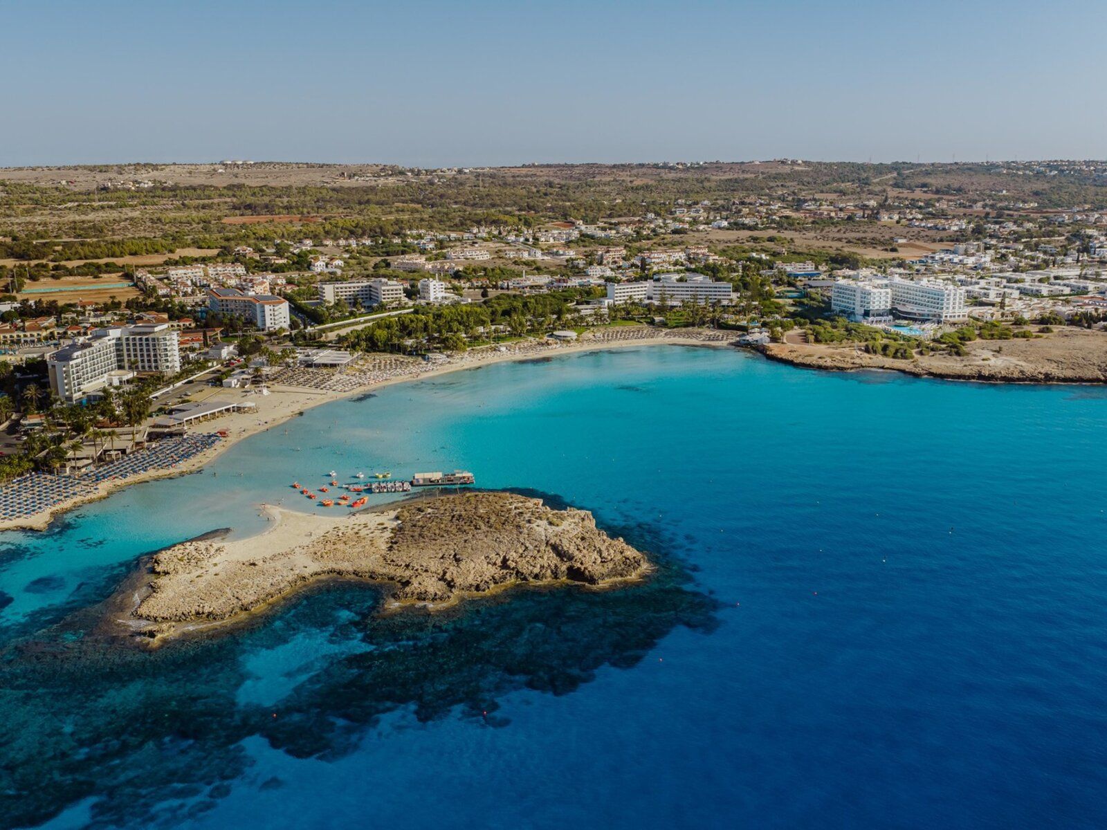 http://Plage%20de%20Nissi%20Beach%20à%20Chypre%20avec%20eau%20turquoise%20et%20îlot%20rocheux