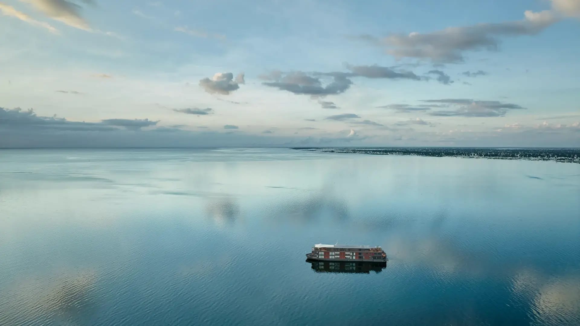 http://Bateau%20de%20croisière%20naviguant%20sur%20une%20rivière%20calme%20au%20cœur%20de%20paysages%20asiatiques