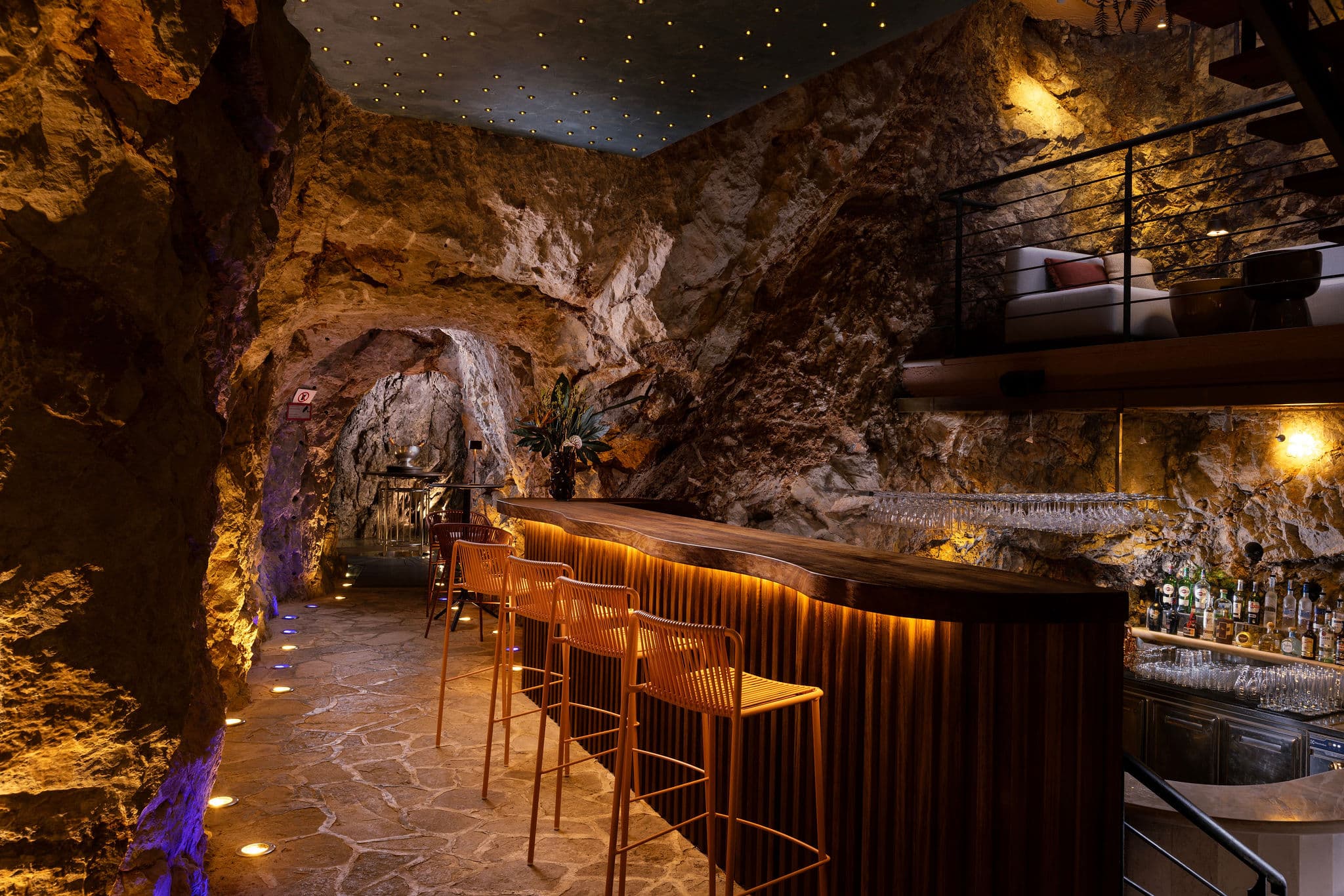http://Bar%20aménagé%20dans%20une%20grotte%20avec%20éclairage%20chaleureux%20et%20ambiance%20luxe