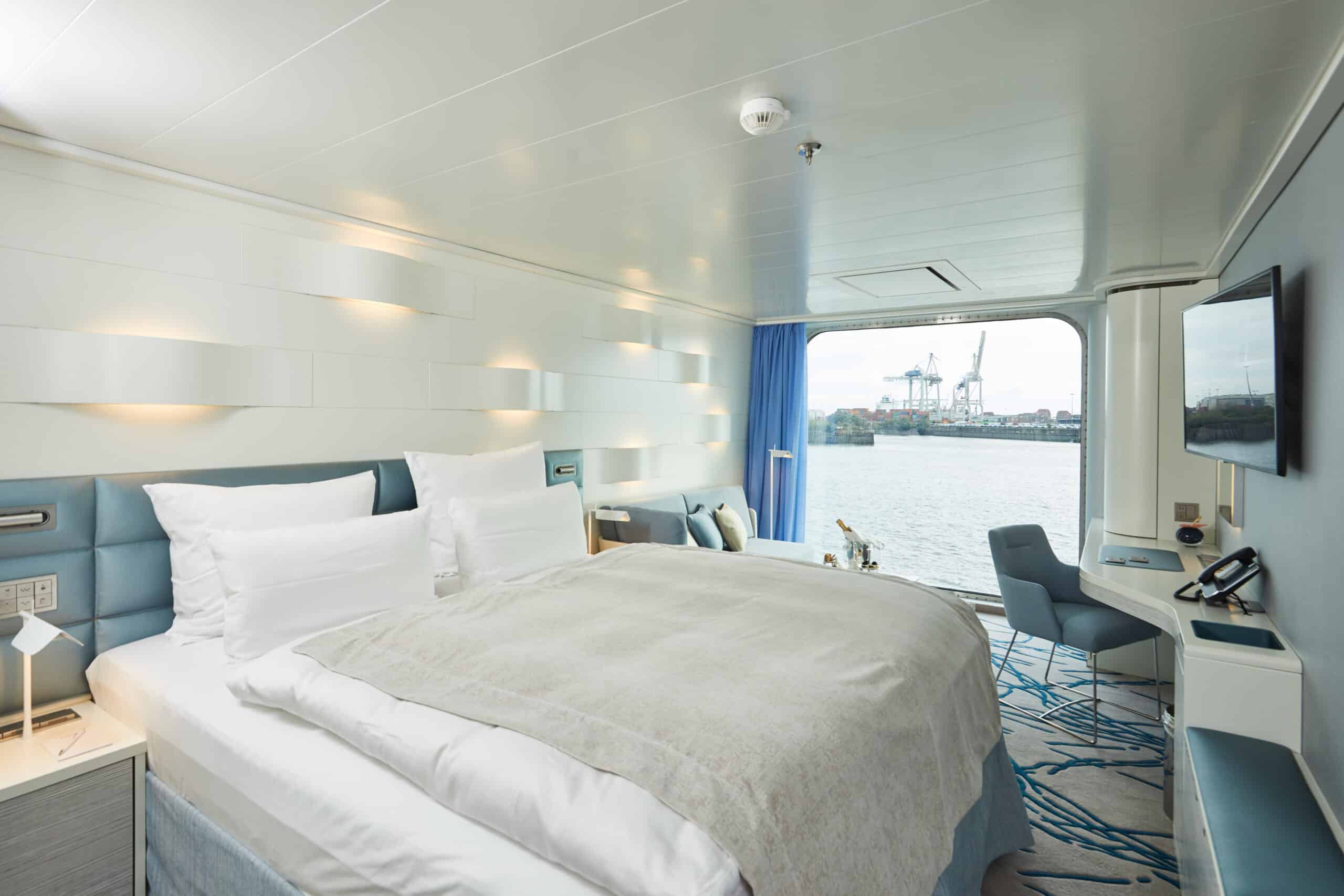 http://Cabine%20moderne%20et%20lumineuse%20avec%20grand%20lit%20et%20vue%20sur%20le%20port%20depuis%20un%20navire