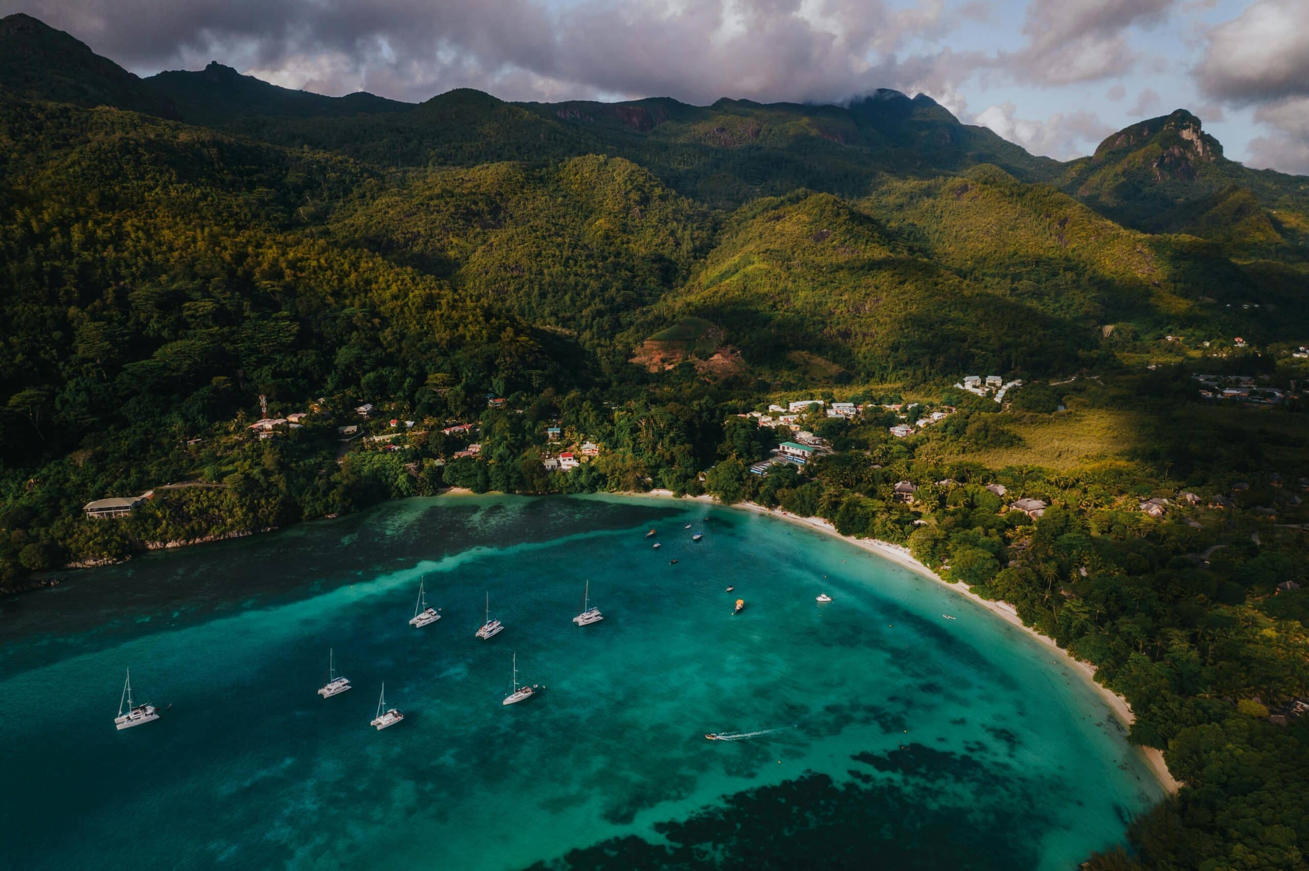 http://Vue%20aérienne%20d’une%20baie%20tropicale%20avec%20eau%20turquoise,%20bateaux%20et%20montagnes%20verdoyantes