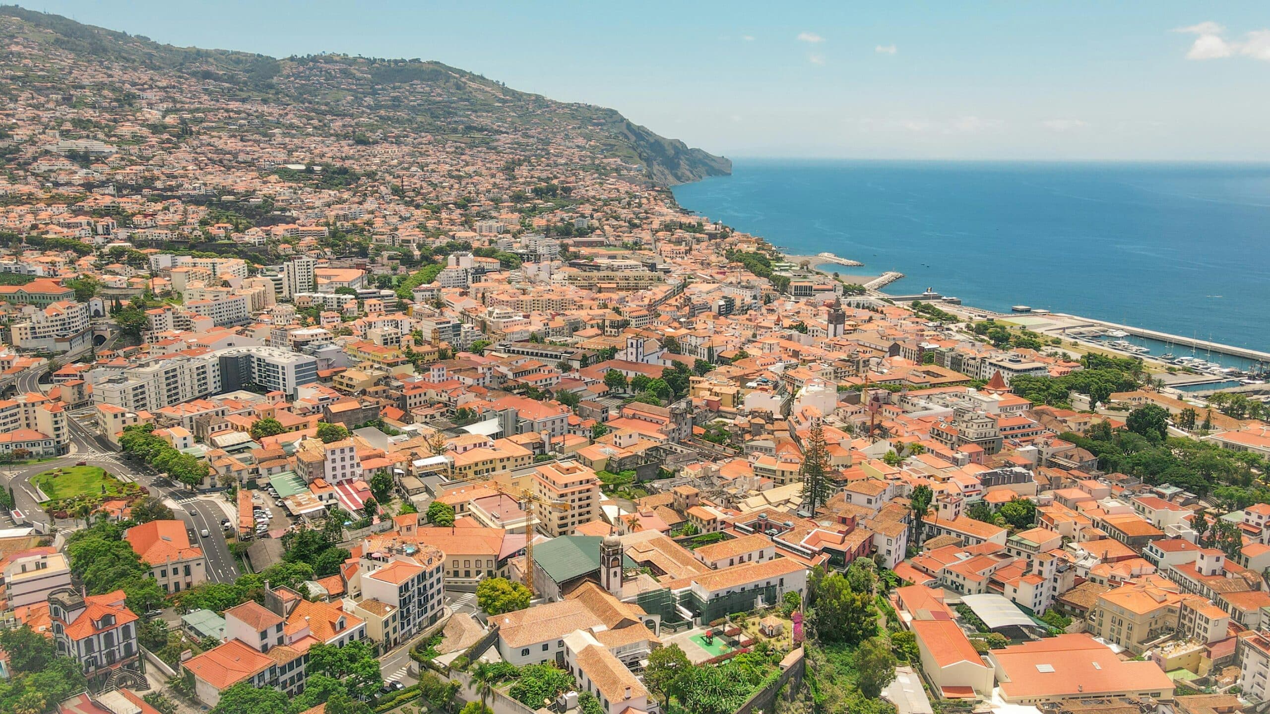 http://Vue%20aérienne%20d’une%20ville%20côtière%20avec%20toits%20rouges%20et%20port%20en%20bord%20de%20mer