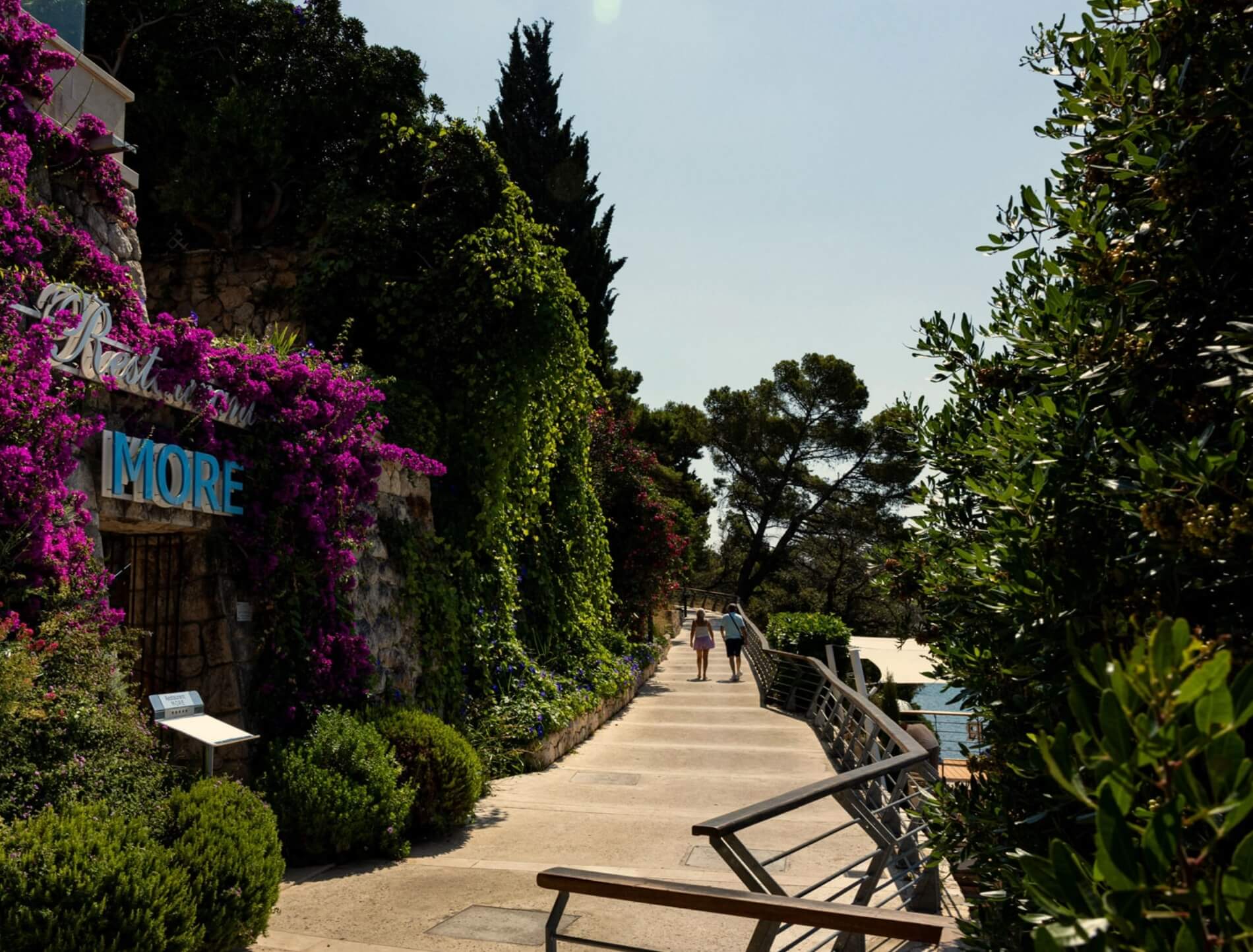 http://Allée%20piétonne%20bordée%20de%20fleurs%20et%20végétation%20menant%20à%20la%20mer%20dans%20un%20hôtel