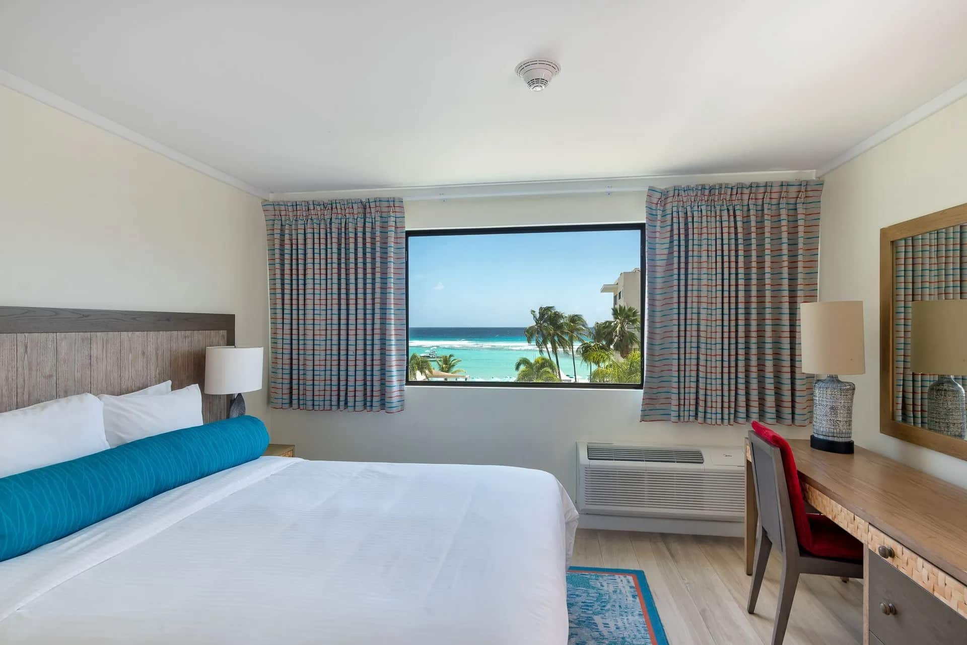 http://Chambre%20d’hôtel%20lumineuse%20avec%20lit%20double%20et%20vue%20sur%20l’océan%20turquoise%20depuis%20une%20grande%20fenêtre%20aux%20Bahamas.
